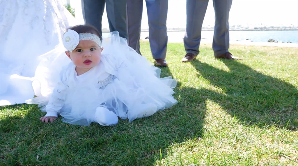 Daniela's baby wearing a white dress at the wedding